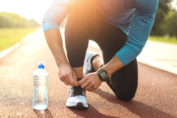 Person preparing walking shoes and water bottle on a kitchen counter